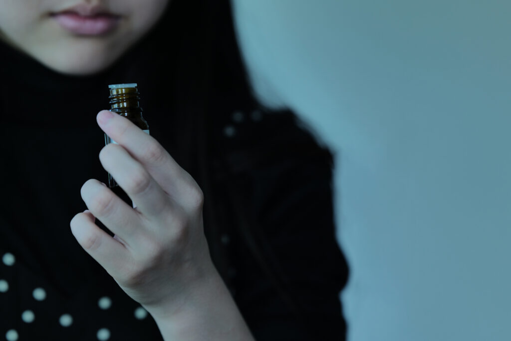 女の子が精油をもって香りを嗅いでいるところ