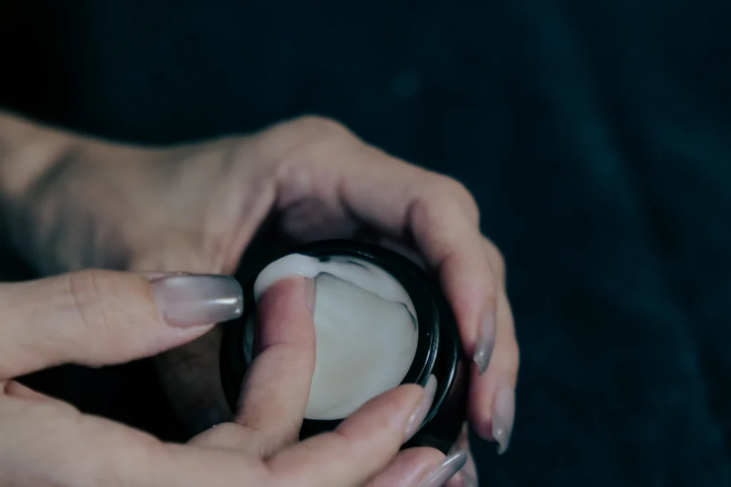 ガラスの器からクリームを取っている手元