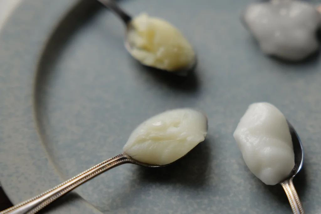 お皿の上にいろいろな種類のクリームののったスプーンが数本