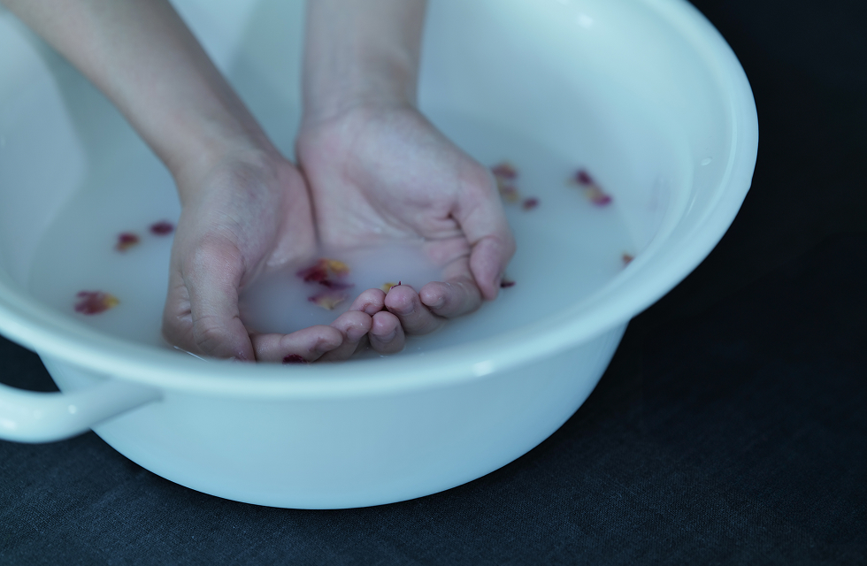 白いホーローのボウルで手浴している様子