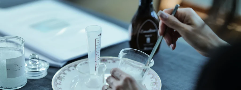 ガラスのビーカーの中でクリームを混ぜている様子