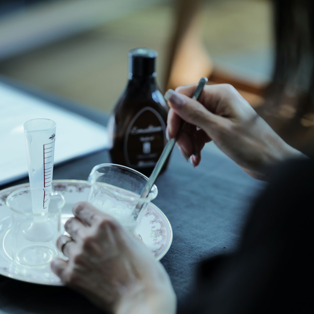 ガラスのビーカーの中でクリームを混ぜている様子